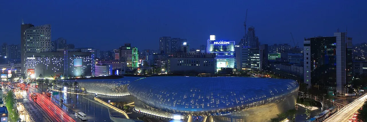 Panoramic night view of Dongdaemun Design Plaza lit up with city lights and traffic