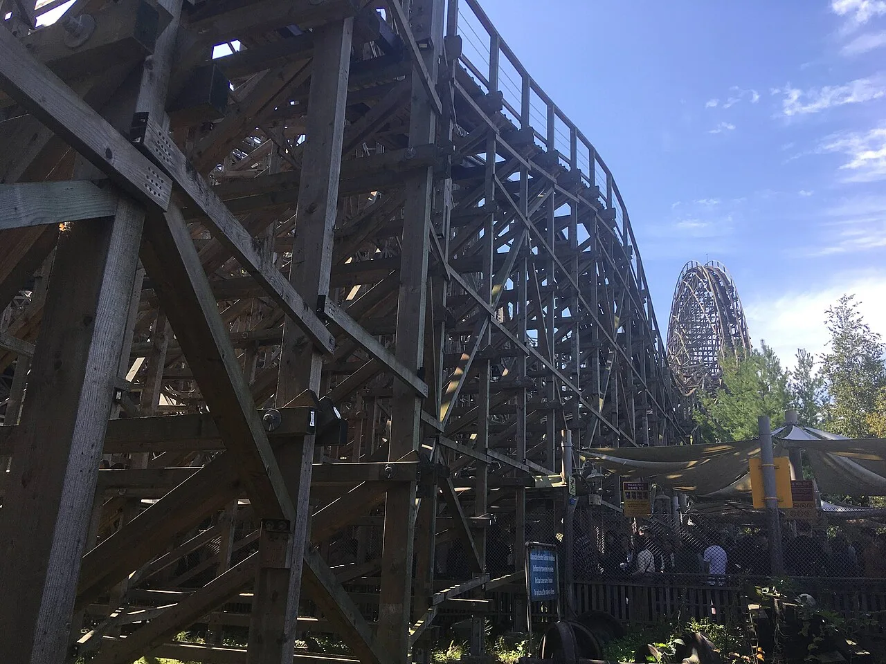 The wooden structure of the T Express roller coaster at Everland against a blue sky