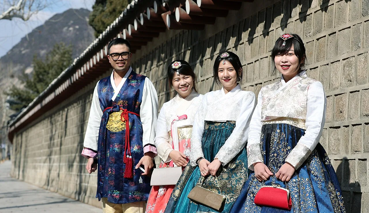 Visitors wearing colourful hanbok walking through the courtyards of Gyeongbokgung Palace