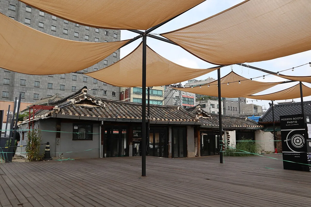 A courtyard of hanok buildings in Ikseon-dong shaded by canvas sails