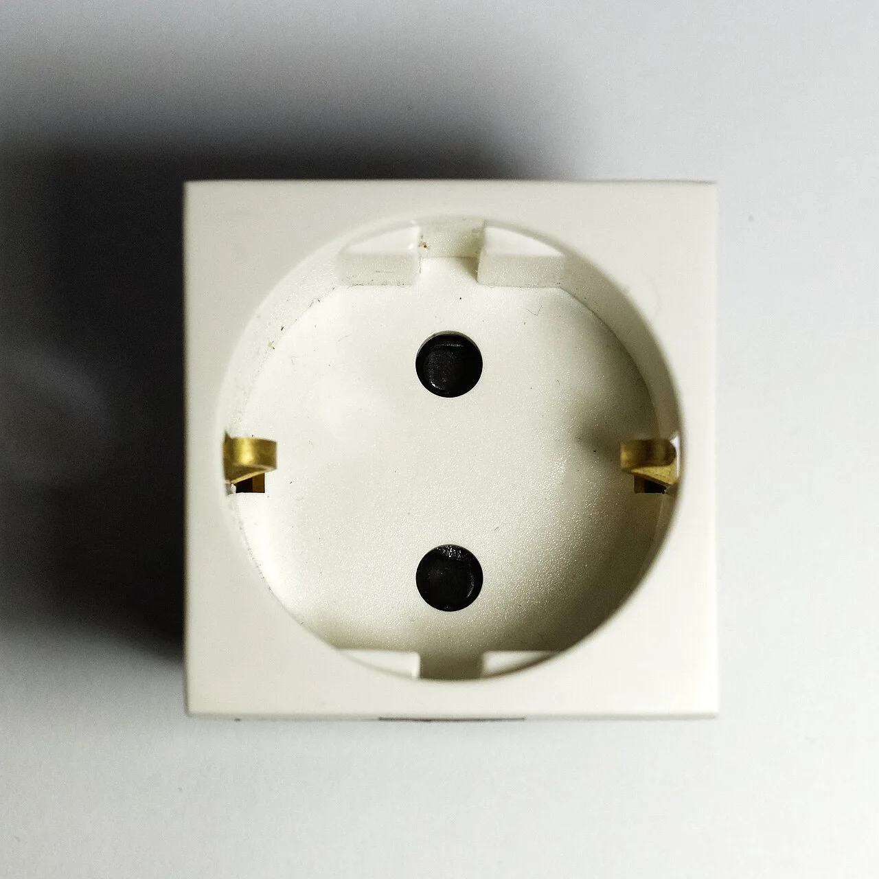 Close-up of a Type F Schuko wall socket with two round holes and side earth clips