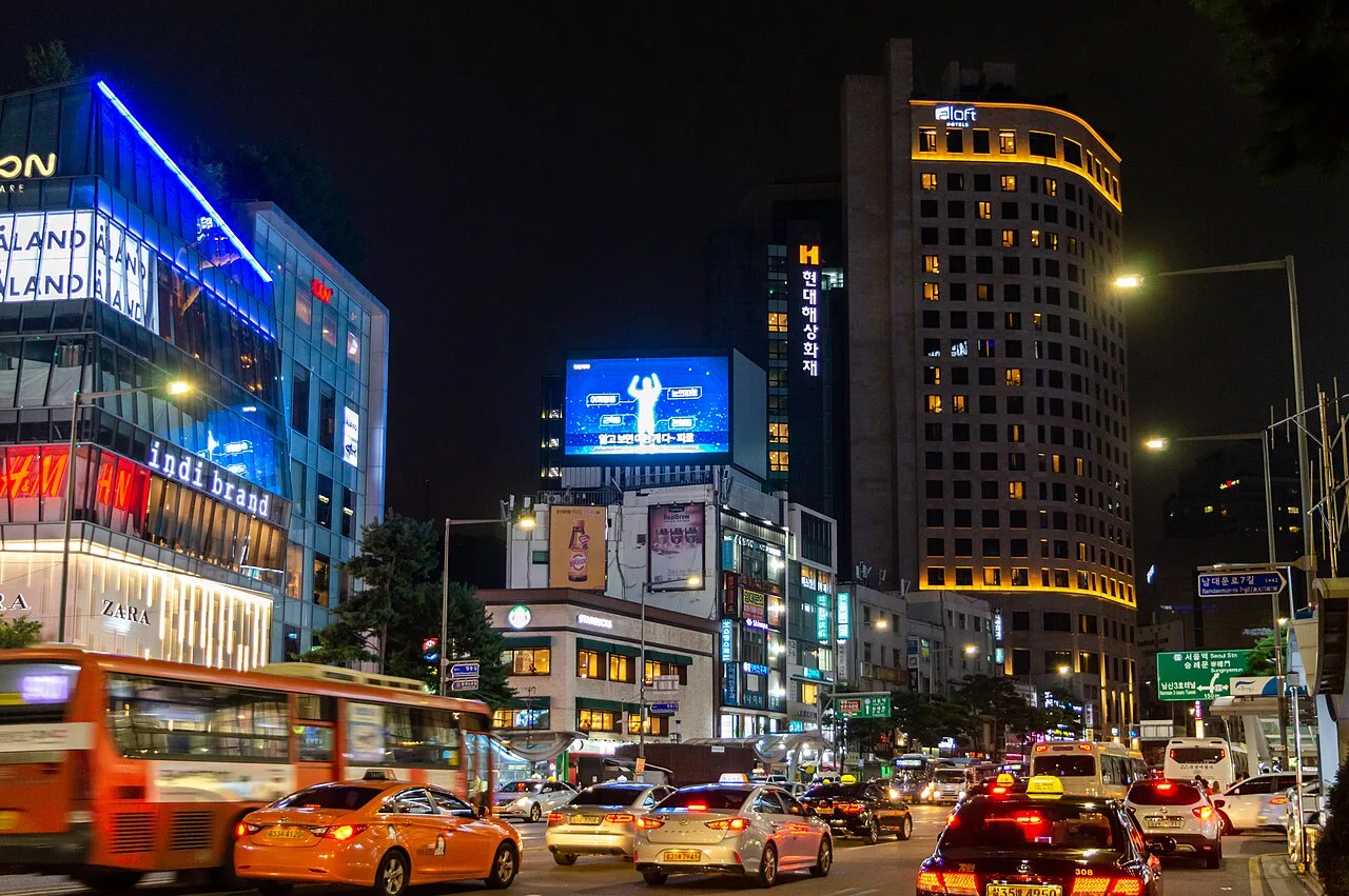 Namdaemun-ro at night with traffic, buses and lit hotel towers near Myeongdong