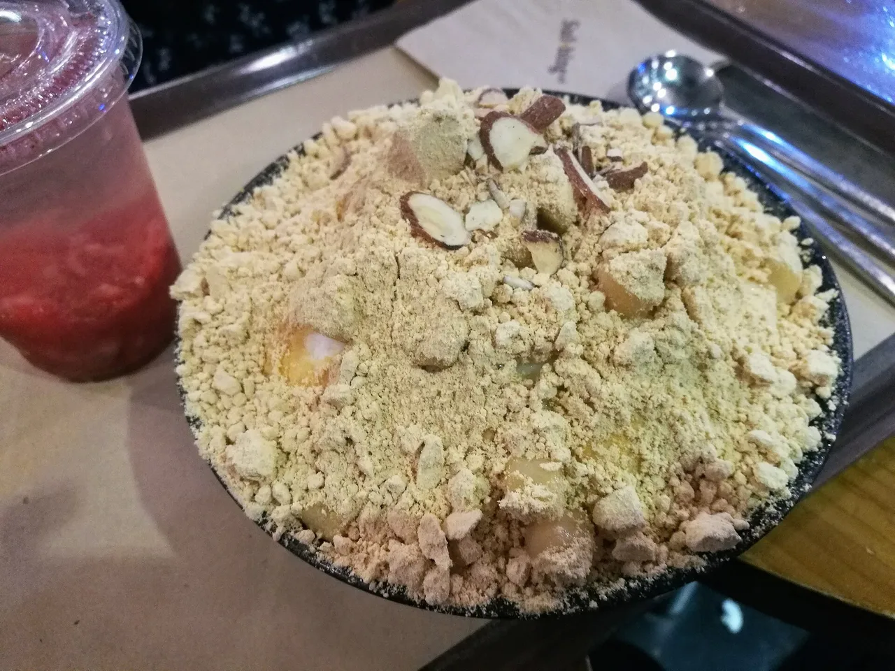 A bowl of Korean injeolmi bingsu, shaved ice topped with roasted soybean powder and rice cake pieces