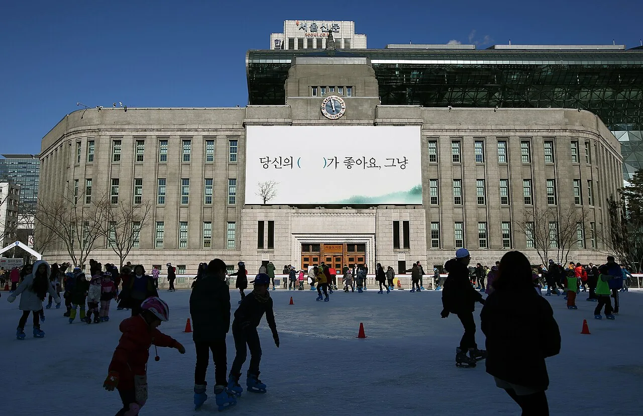 Families skating on the Seoul Plaza ice rink in front of Seoul City Hall in winter