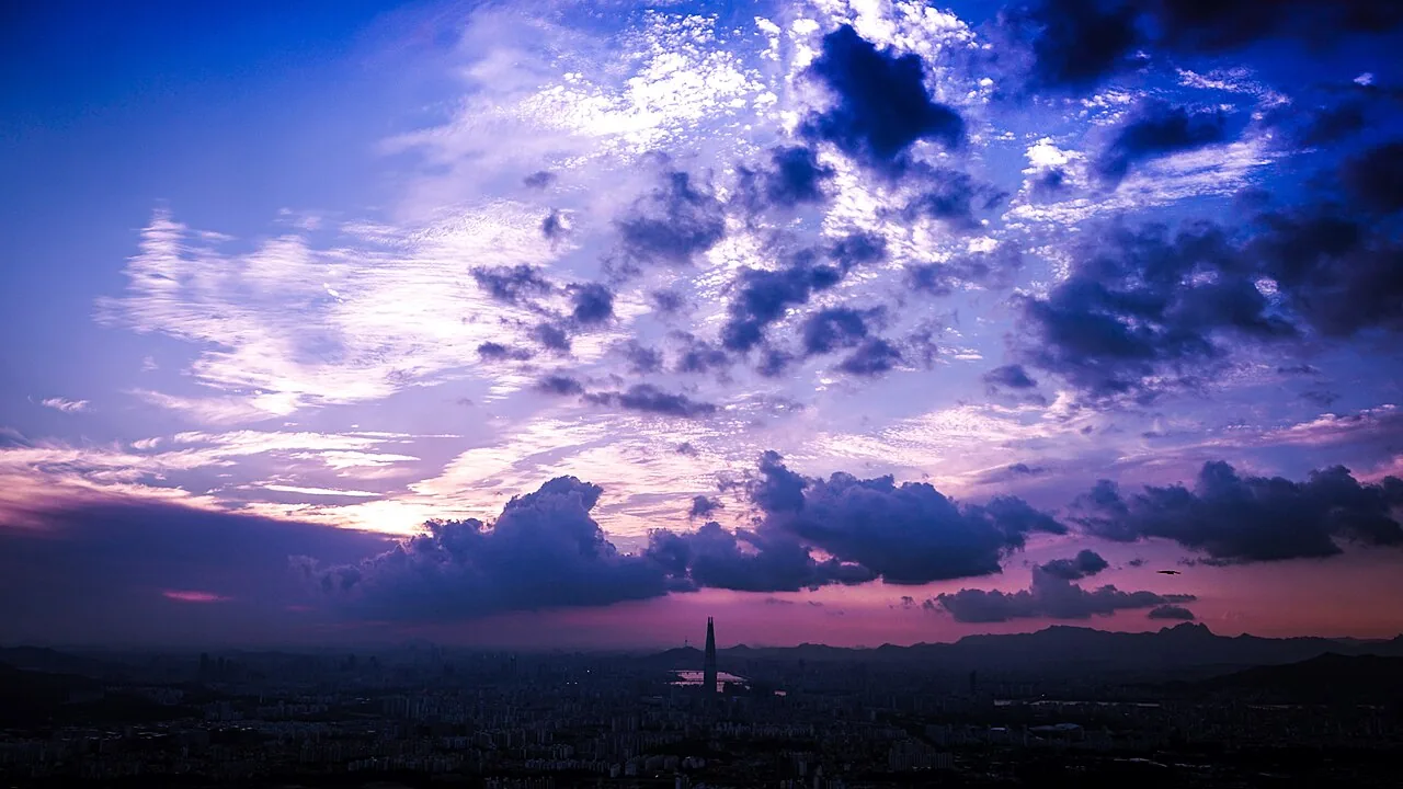 Lotte World Tower rising above Seoul under a purple dusk sky