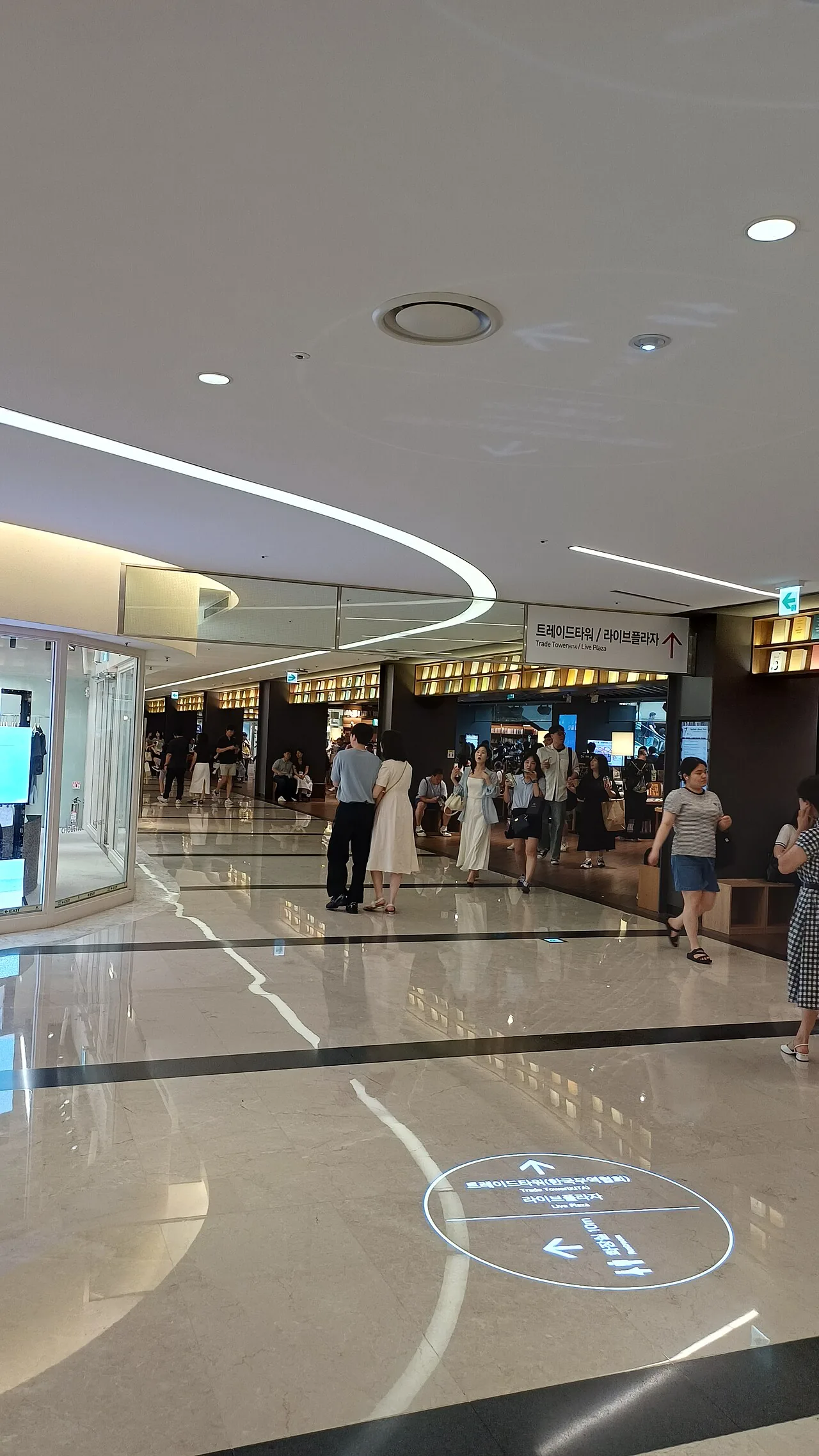 Shoppers walking through a wide corridor inside COEX Mall in Seoul