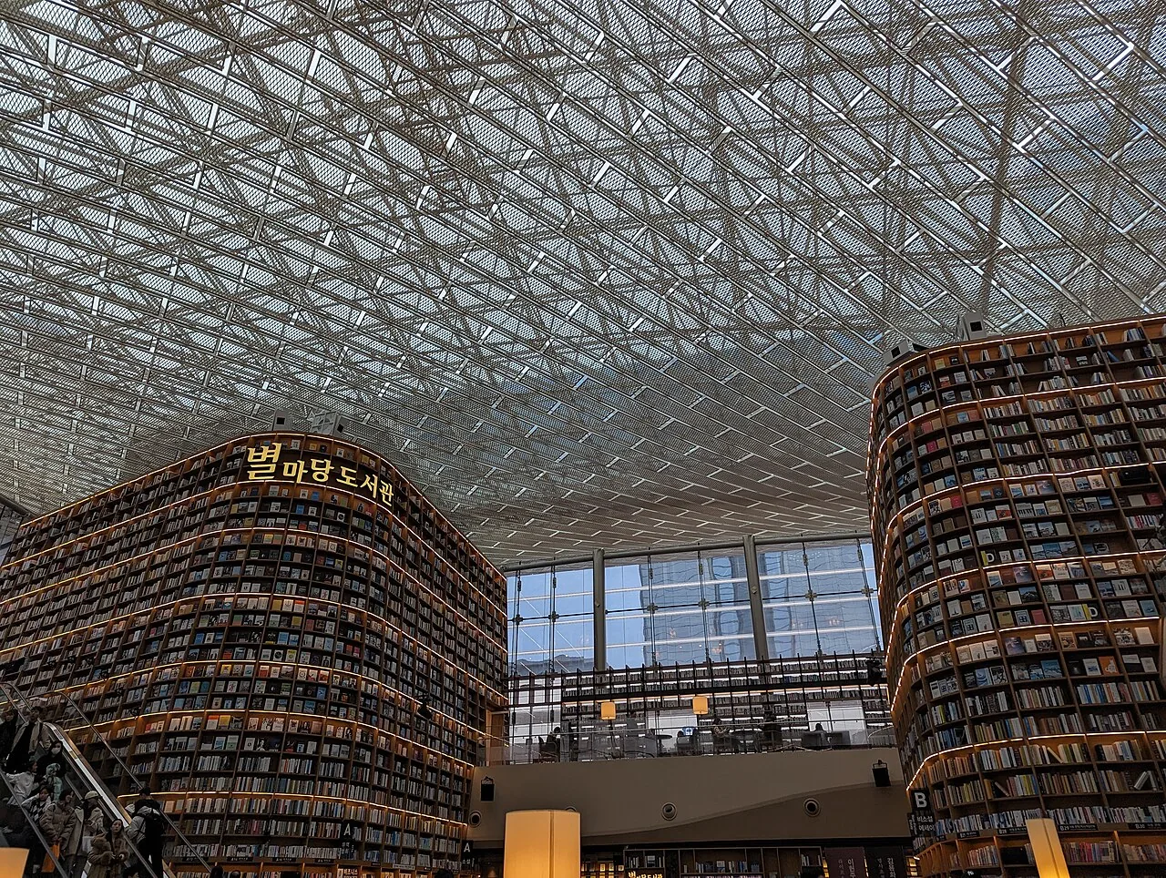 Visitors walking beneath tall bookshelves in Starfield Library at COEX