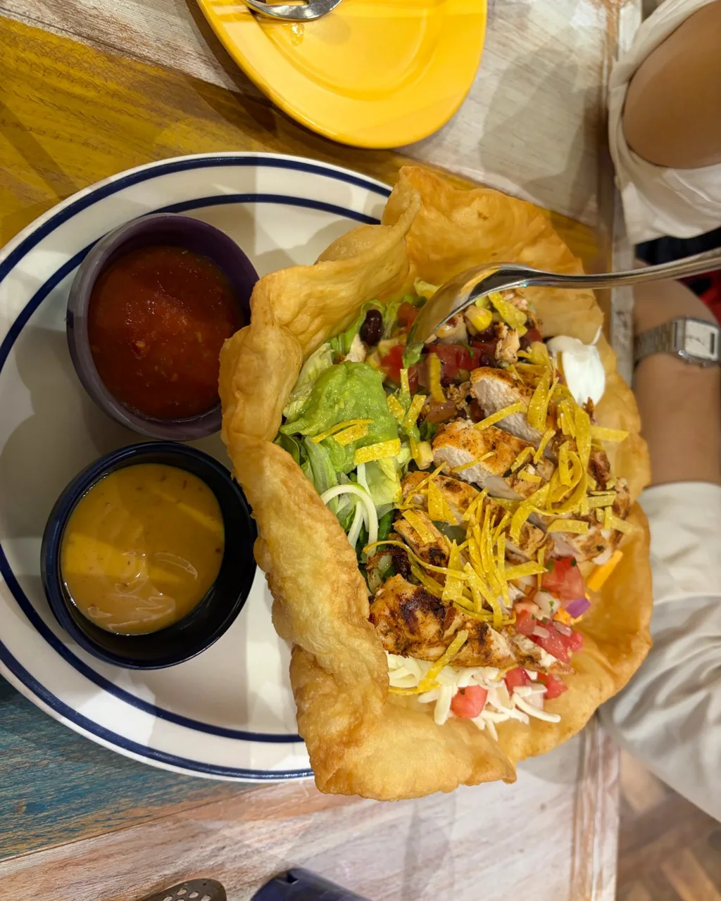 Taco salad in a fried tortilla bowl with dips at Sugar Skull Central City
